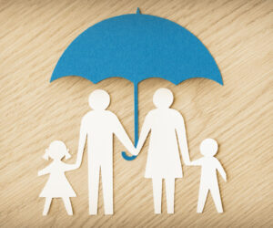 Paper,Family,Silhouette,With,Umbrella,On,Wooden,Background,-,Concept